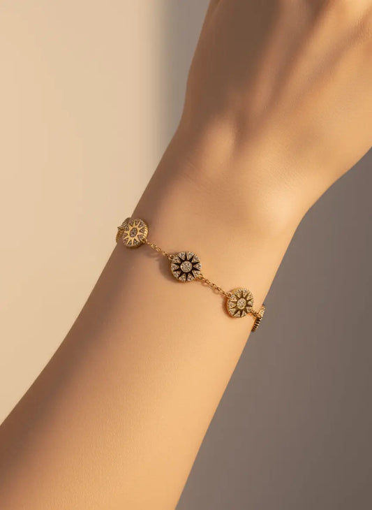 سوار مطلي بالذهب مزين بتعليقة على شكل عملة معدنية ومرصع بالزركون