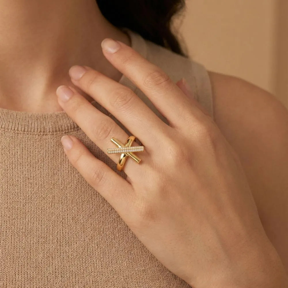Gold ring on a hand against a neutral background