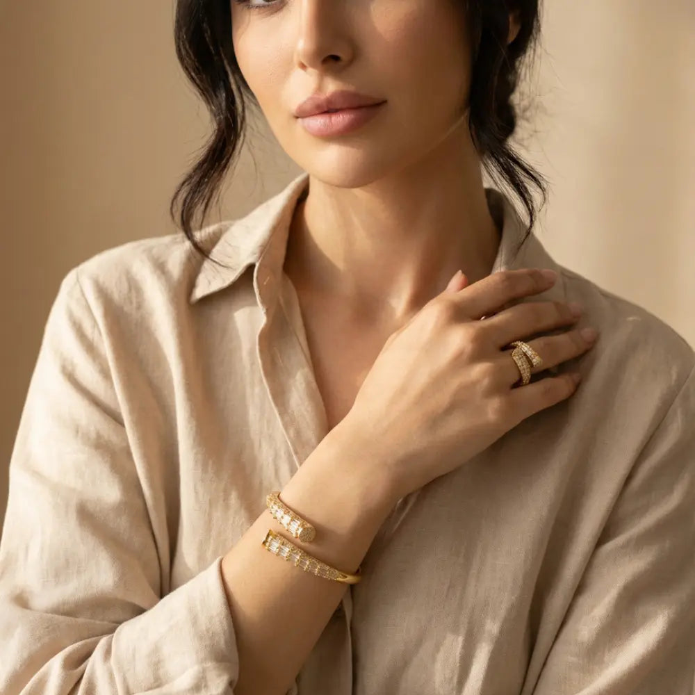 Woman wearing gold jewelry including a bracelet and ring