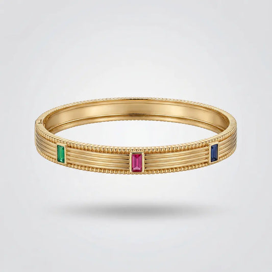 Gold bracelet with gemstones on a light gray background