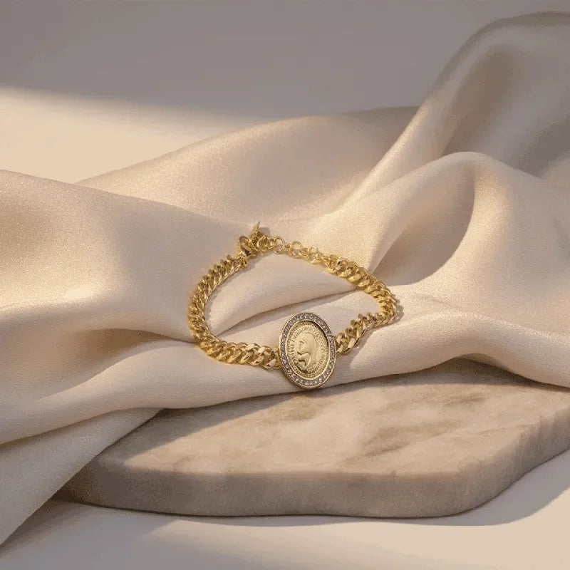 Elegant gold jewelry set including a long necklace and drop earrings with fan-shaped motifs on soft satin.