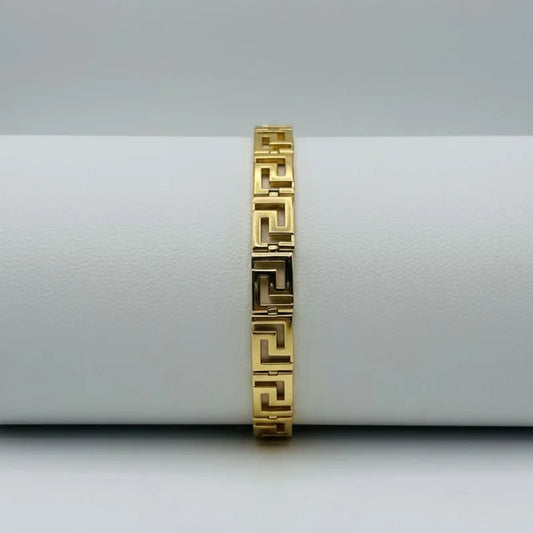 gold-plated Greek key bracelet on a white surface