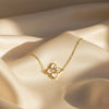 Gold bracelet with a floral pendant on a beige fabric background
