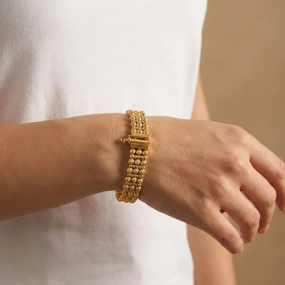  Gold Plated Ribbed Bead Bracelet on a wrist with a neutral background