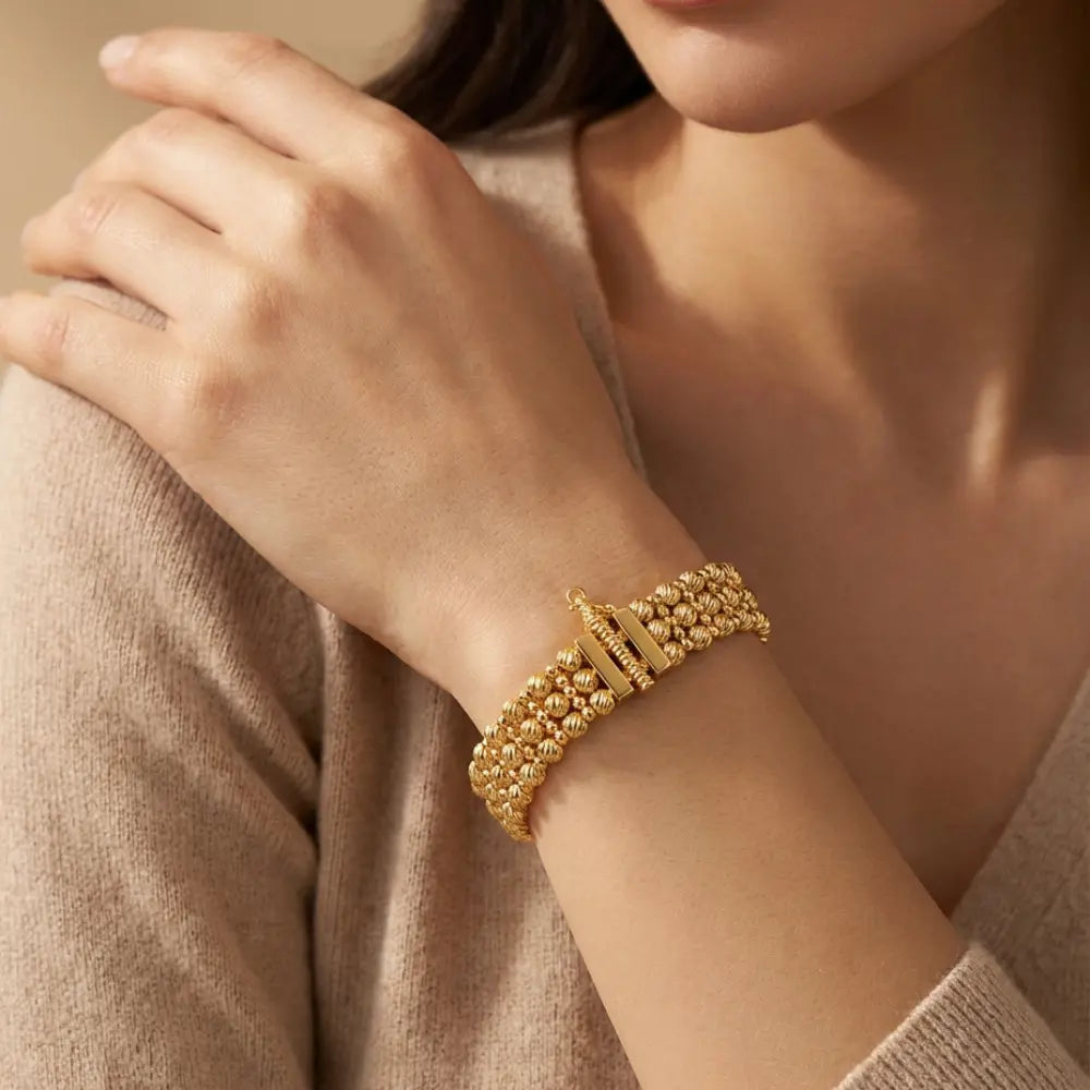  Gold Plated Ribbed Bead Bracelet on a person's wrist with a neutral background