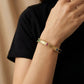 Gold Plated hinged bangle Baguette Gemstone on a person's wrist against a black background