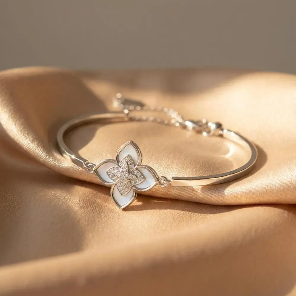 Silver bracelet with a floral design on a beige fabric background