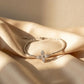 Silver bracelet with a floral clasp on beige fabric