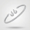 Silver tennis bracelet and curved stud earrings with baguette-cut diamonds on a neutral background.