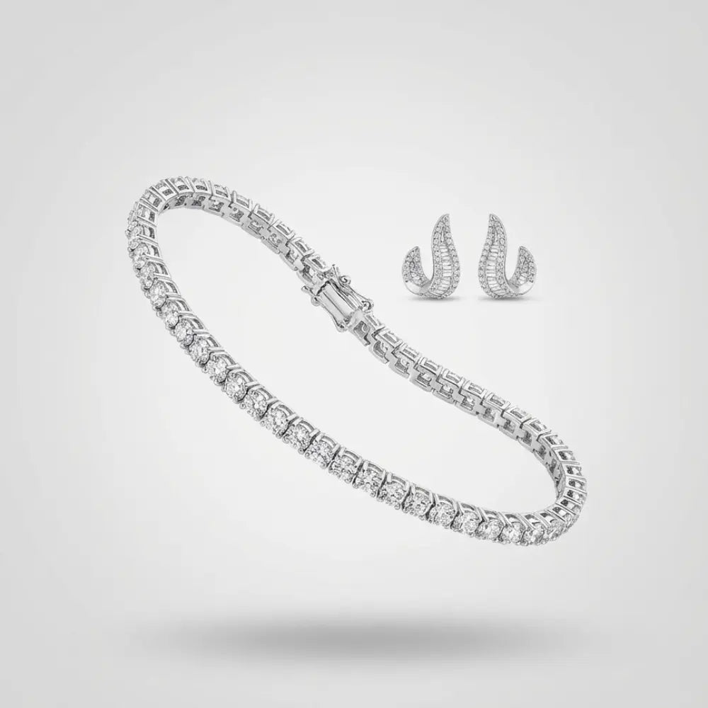 Silver tennis bracelet and curved stud earrings with baguette-cut diamonds on a neutral background.