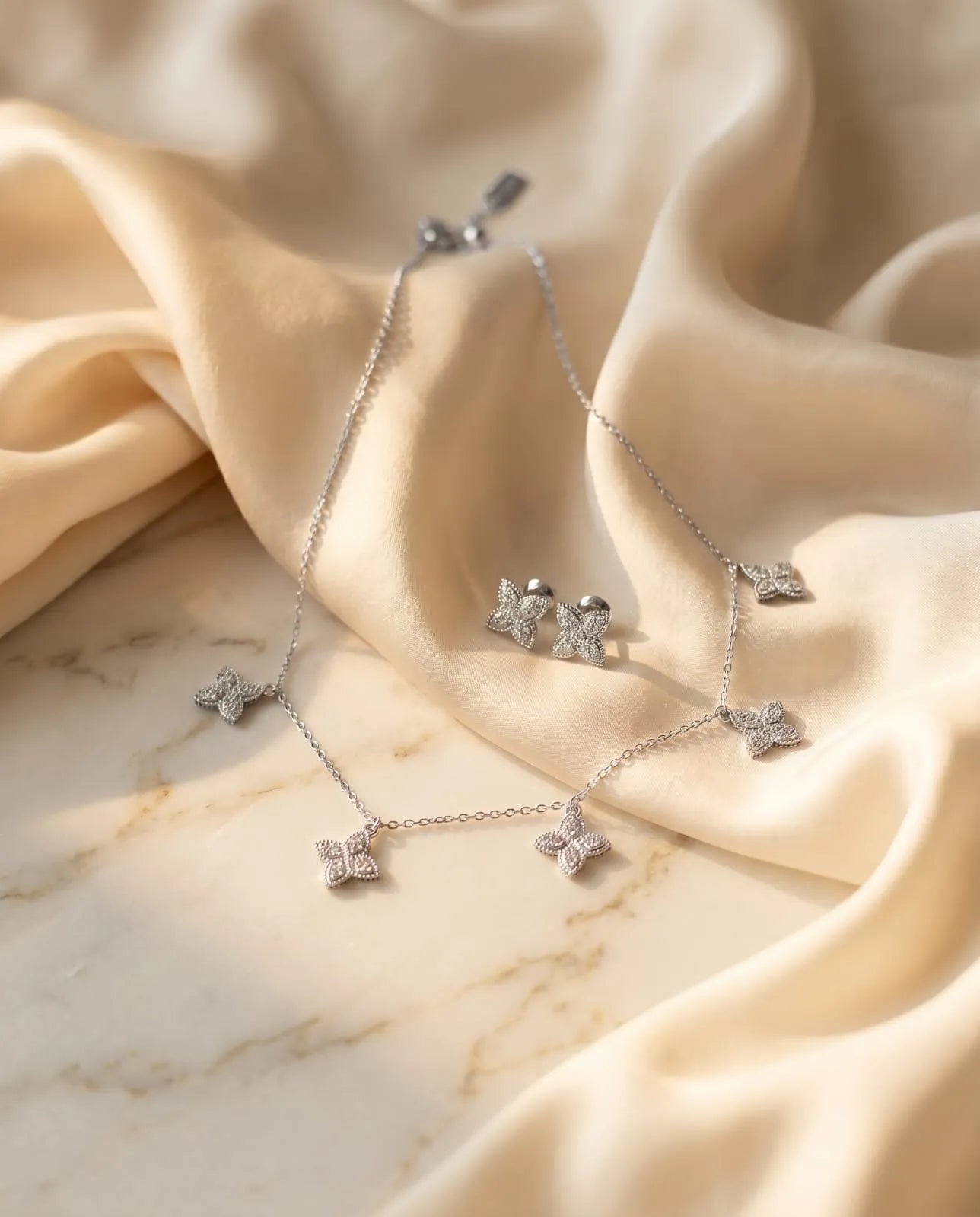 Elegant Silver Butterfly Necklace and matching Stud Earrings set adorned with shimmering stones.